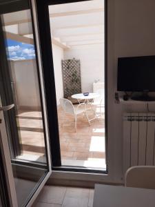 een balkon met een tafel en een televisie bij La Vela Apartaments - Porto Cesareo in Porto Cesareo