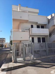 een poort voor een wit gebouw bij La Vela Apartaments - Porto Cesareo in Porto Cesareo