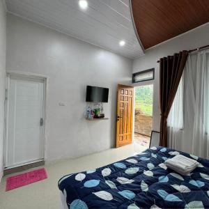 um quarto com uma cama, uma janela e uma porta em Sapo Rumbia Villa & Hotel em Berastagi