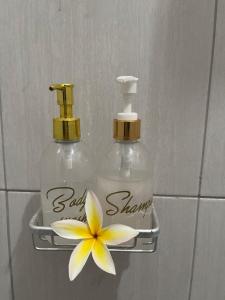 two bottles of soap and a flower on a wall at Canggu Nadi 2 Guest House in Canggu