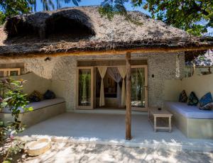 a house with a thatched roof and a patio at Sharazad Boutique Hotel in Jambiani