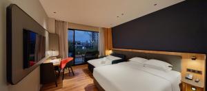 een hotelkamer met een groot wit bed en een bureau bij Holiday Inn Express Chiayi, an IHG Hotel in Chiayi City