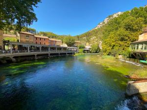 Un río en un pueblo con un puente sobre él en Loca-Moulins, en Saze