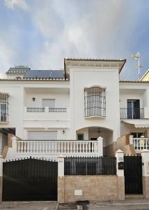 una casa bianca con una recinzione nera davanti di Villa Jara 25 a Nerja