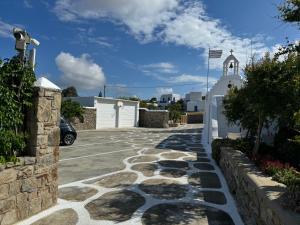 una entrada con una pasarela de piedra y un edificio blanco en Anais en Mykonos ciudad
