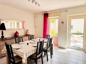 comedor con mesa, sillas y ventana en Loca-Moulins, en Saze
