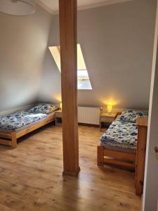 a room with two beds and a beam at Zielony Dom in Wolin