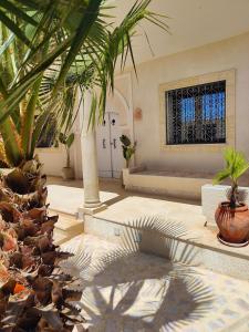 a living room with palm trees and a window at Villa Nour Kélibia in Kelibia