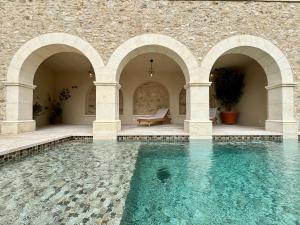a swimming pool in a stone building with blue water at L'Iris de Suse in Le Barroux