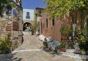 Arolithos Traditional Village Hotel في Tílisos: زقاق في مدينة قديمة مع مباني