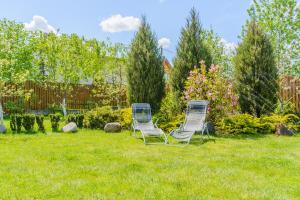 two chairs sitting in the grass in a yard at Trijų žvaigždučių palapinė Vilniuje in Vilnius