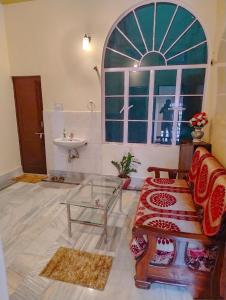 - un salon avec un lavabo, un canapé et une fenêtre dans l'établissement Rani Villa Family HomeStay, à Varanasi