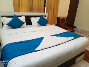 uma cama grande com almofadas azuis e brancas em Rani Villa Family HomeStay em Varanasi