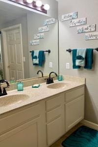 a bathroom with two sinks and a large mirror at Gated Mountain View Resort Community, Centrally Located, Three Heated Pool-Spa Complexes, Half-Mile To Hiking! in Phoenix