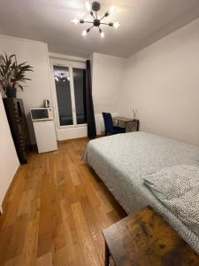 a bedroom with a bed and a table and a window at Private room center Paris in Paris