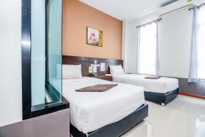 ein Hotelzimmer mit 2 Betten und einem Fenster in der Unterkunft The one boutique hotel in Satun