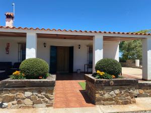 a front porch of a house with a stone wall at Casa Rural La Loba in Malcocinado