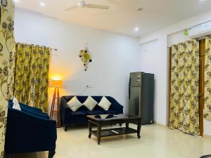 a living room with a blue couch and a table at Green View Apartments F1 in Varanasi