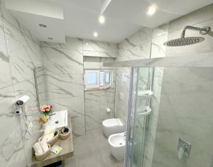a bathroom with a toilet and a glass shower at Marco House - Seaview Apartment - Fronte Mare - Case Vacanza Anzio in Anzio +11 photos