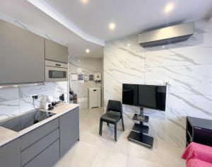 een keuken met een tv en een stoel in een kamer bij Marco House - Seaview Apartment - Anzio in Anzio