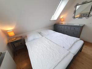 Dormitorio con cama con espejo y tocador en Am Kampland 25b en Dahme