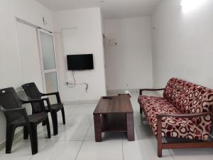 - un salon avec un canapé, des chaises et une table dans l'établissement Laasya Comforts, à Mangalore