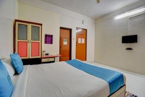 a bedroom with a large bed and a television at Hotel Silver Inn in Mahabaleshwar