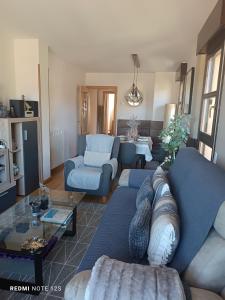 ein Wohnzimmer mit einem blauen Sofa und einem Tisch in der Unterkunft Apartamento Mirador del Pantano2 in Vinuesa