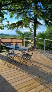una mesa de picnic en una terraza de madera bajo un árbol en Torretta Glamping & Relax, en Arola