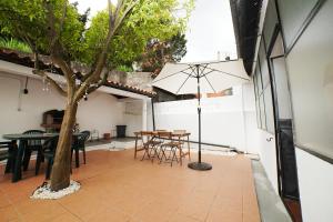 a patio with a table and chairs and a tree at Casa da Laranja by Quantique in Peso da Régua