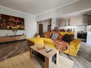 sala de estar con sofá amarillo y mesa en VICTORIA HOUSE, en Kavala