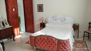 1 dormitorio con 1 cama con colcha blanca en Domaine des Sloughis, en Meknès