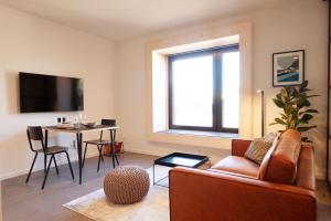 ein Wohnzimmer mit einem Sofa und einem Tisch in der Unterkunft Mono Design Apartments in Stuttgart