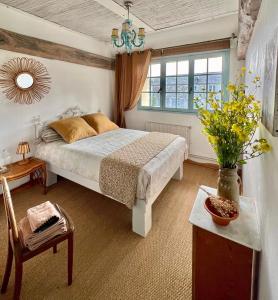 1 dormitorio con cama, mesa y ventana en Chambres d'Hôtes Manoir Du Chêne en Nonant