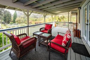 a screened porch with chairs and a table and a table at Aloha Junction Guest House - 5 min from Hawaii Volcanoes National Park in Volcano