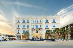 利雅德Luxury Night Al Munsiyah的一座巨大的白色建筑，前面有棕榈树