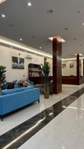 een woonkamer met een blauwe bank in de lobby bij مارينا نجد للشقق الفندقية in Hotat bani tamim