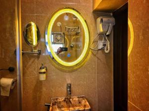 ein Badezimmer mit einem Spiegel und einem Waschbecken in der Unterkunft Deepalay Heritage room2 in Kalkutta
