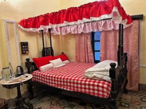 Schlafzimmer mit einem roten und weißen Bett mit Baldachin in der Unterkunft Deepalay Heritage room2 in Kalkutta