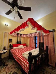 Schlafzimmer mit einem Himmelbett und einem Deckenventilator in der Unterkunft Deepalay Heritage room2 in Kalkutta