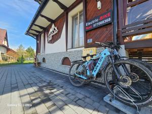 uma bicicleta estacionada ao lado de um edifício em GÓRALSKA VILLA APARTAMENTY Z JACUZZI & HOME SPA & Zakopane em Poronin