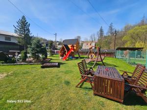 a park with a playground with two chairs and a table at GÓRALSKA VILLA APARTAMENTY Z JACUZZI & HOME SPA & Zakopane in Poronin