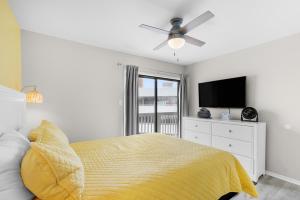 格尔夫海岸Steps to Sand l Ocean views l Smart TVs l Pool的带床和吊扇的卧室