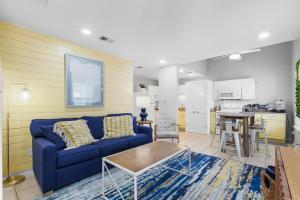 uma sala de estar com um sofá azul e uma cozinha em Steps to Sand l Ocean views l Smart TVs l Pool em Gulf Shores