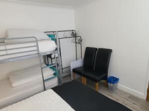 a bedroom with a bunk bed and a chair at GATWICK ROOMs in Ifield