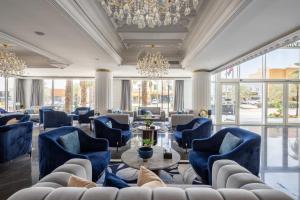 a lobby with blue chairs and tables and a chandelier at Luxury Night Hotel in Riyadh