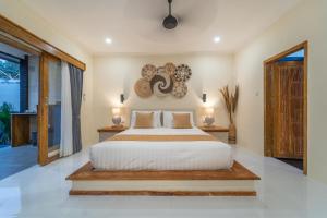 a bedroom with a large bed with areath on the wall at Tanis Village - Luxury Villas in Gili Air
