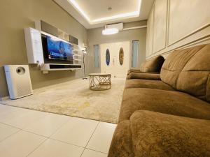 sala de estar con sofá y TV de pantalla plana en Alyn Home Melaka Netflix, en Kampong Kerubong