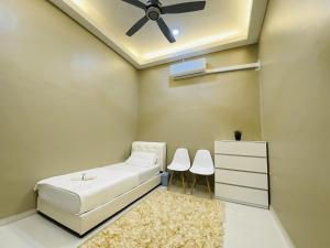1 dormitorio con 1 cama y ventilador de techo en Alyn Home Melaka Netflix, en Kampong Kerubong