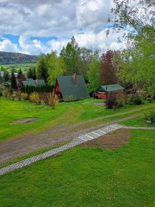 a yard with a stone path and a house at Domki nad potokiem w Baligrodzie in Baligród